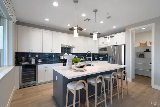 a kitchen with a dining table chairs and white cabinets