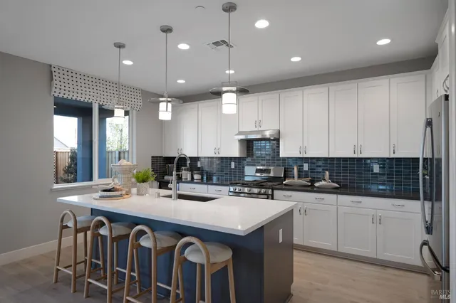 a kitchen with kitchen island a sink dining table and chairs