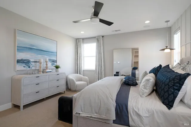 a spacious bedroom with a bed and ceiling fan