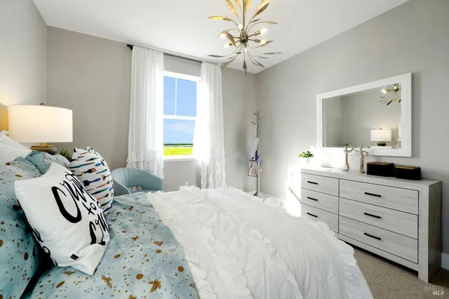 a bedroom with bed and a chandelier