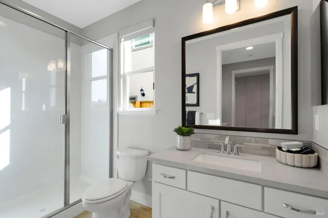 a bathroom with a shower a toilet and a window