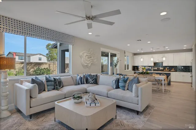 a living room with furniture ceiling fan and a flat screen tv