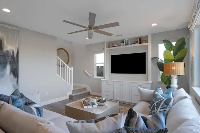 a living room with furniture and a view of kitchen