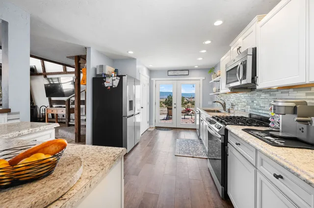 a kitchen with stainless steel appliances granite countertop a refrigerator stove and oven