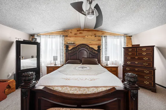 a bedroom with a bed and dresser with mirror