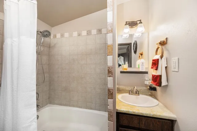 a bathroom with a granite countertop sink and a mirror