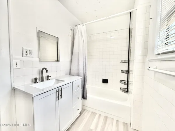 a bathroom with a bathtub a sink a vanity and a shower