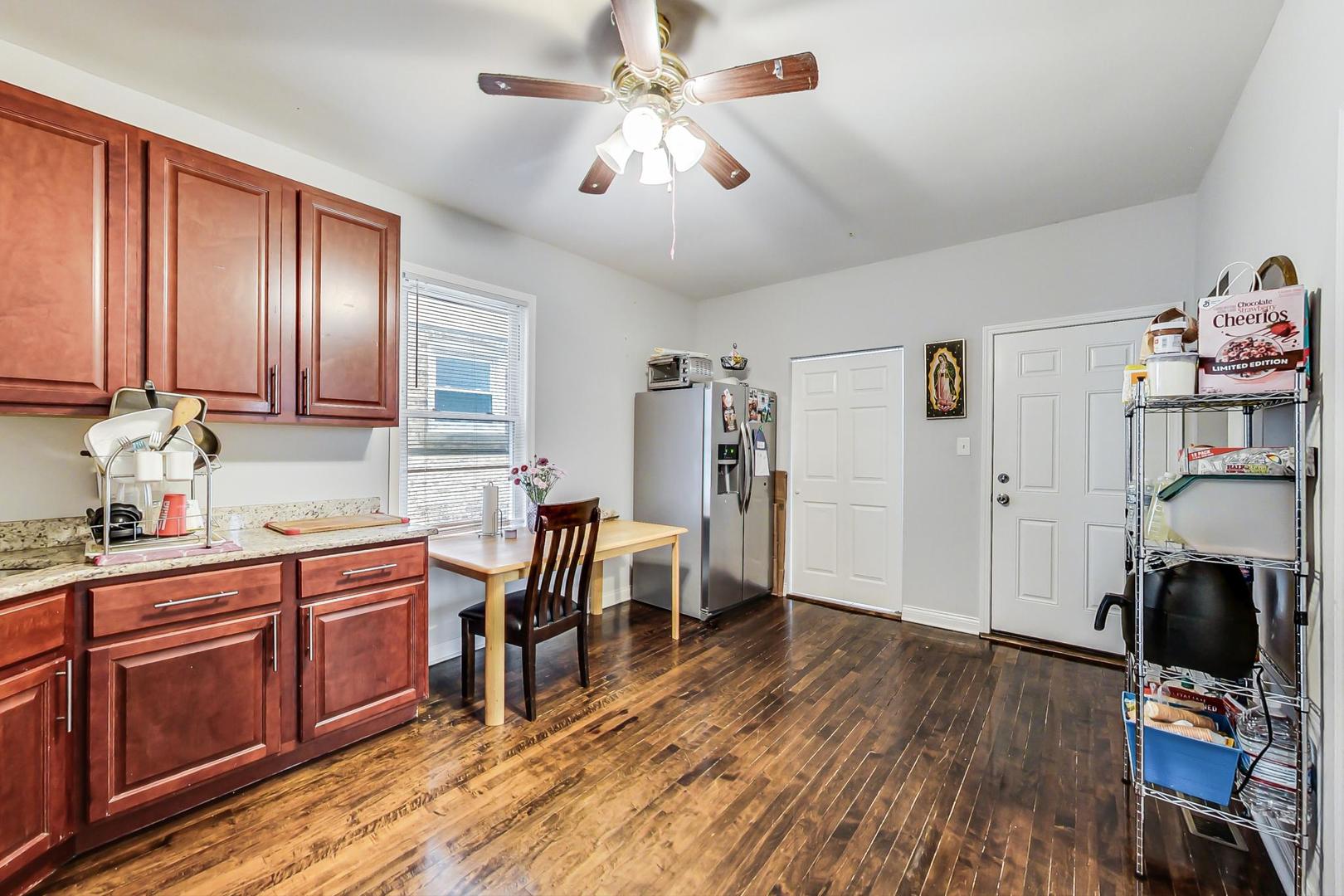 4237 West School Street Chicago, IL 60641 - Photo 11 of 72 a kitchen with stainless steel appliances granite countertop wooden floors a stove and a refrigerator