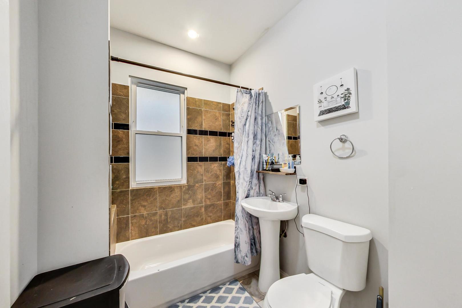 4237 West School Street Chicago, IL 60641 - Photo 13 of 72 a white toilet sitting next to a bath tub