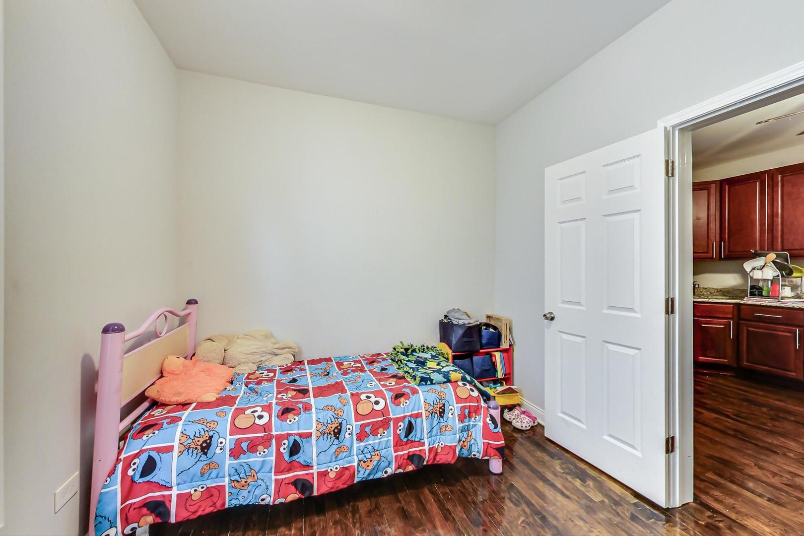 4237 West School Street Chicago, IL 60641 - Photo 19 of 72 a bedroom with a bed and wooden floor