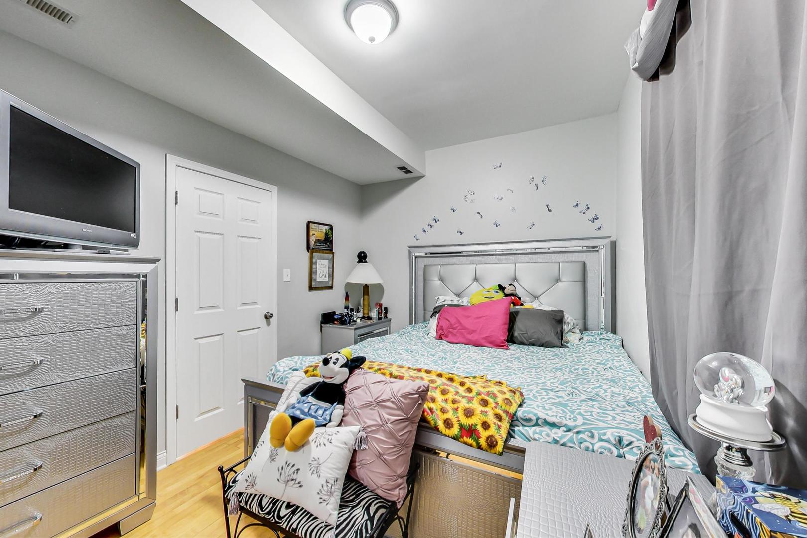 4237 West School Street Chicago, IL 60641 - Photo 30 of 72 a bedroom with a bed and flat screen tv