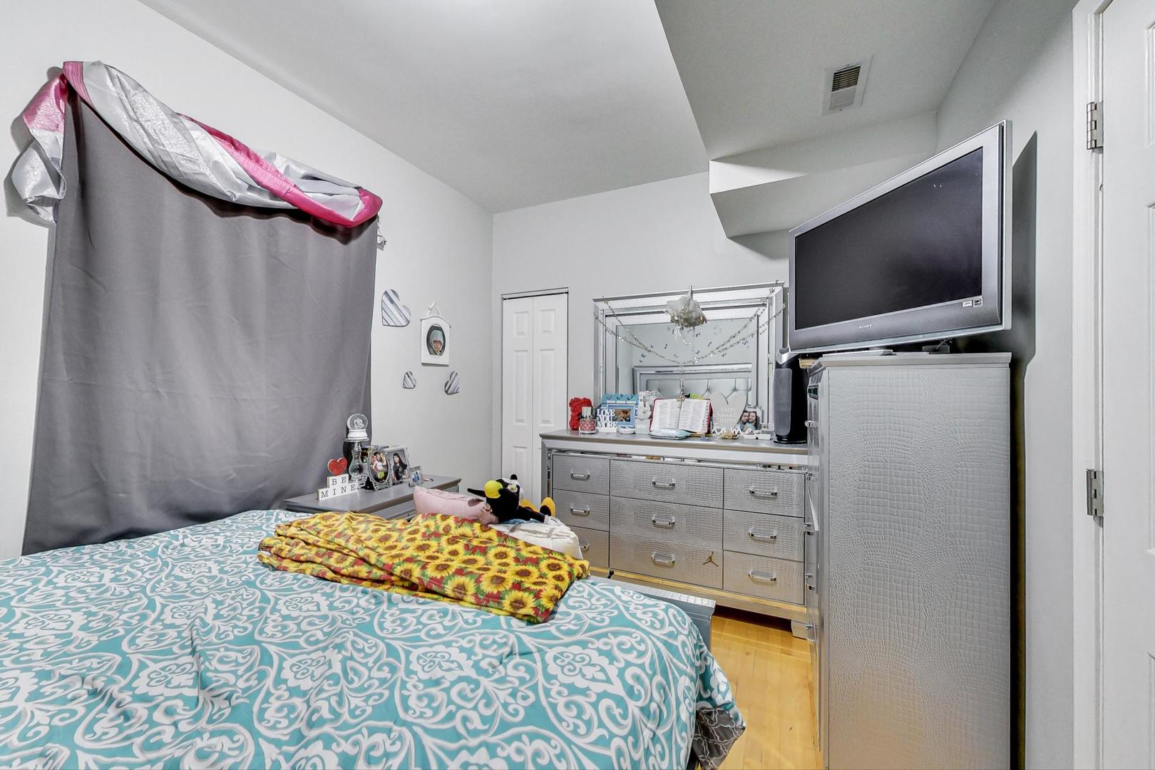 4237 West School Street Chicago, IL 60641 - Photo 31 of 72 a bedroom with a bed and a flat screen tv