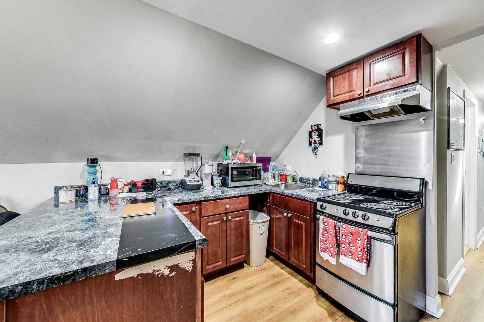 4237 West School Street Chicago, IL 60641 - Photo 44 of 72 a kitchen with stainless steel appliances granite countertop a stove a sink and a microwave