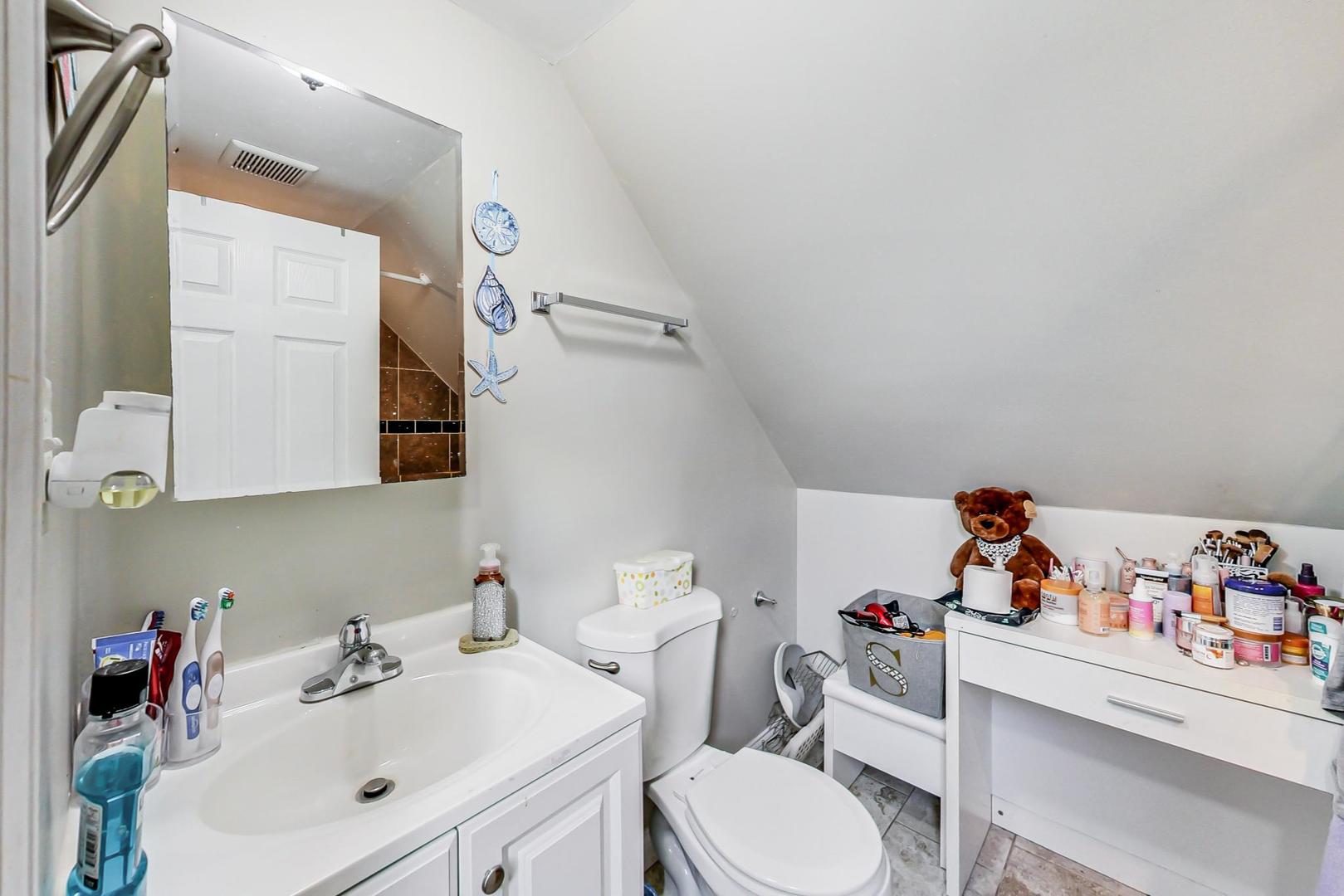 4237 West School Street Chicago, IL 60641 - Photo 46 of 72 a bathroom with a sink mirror and toilet