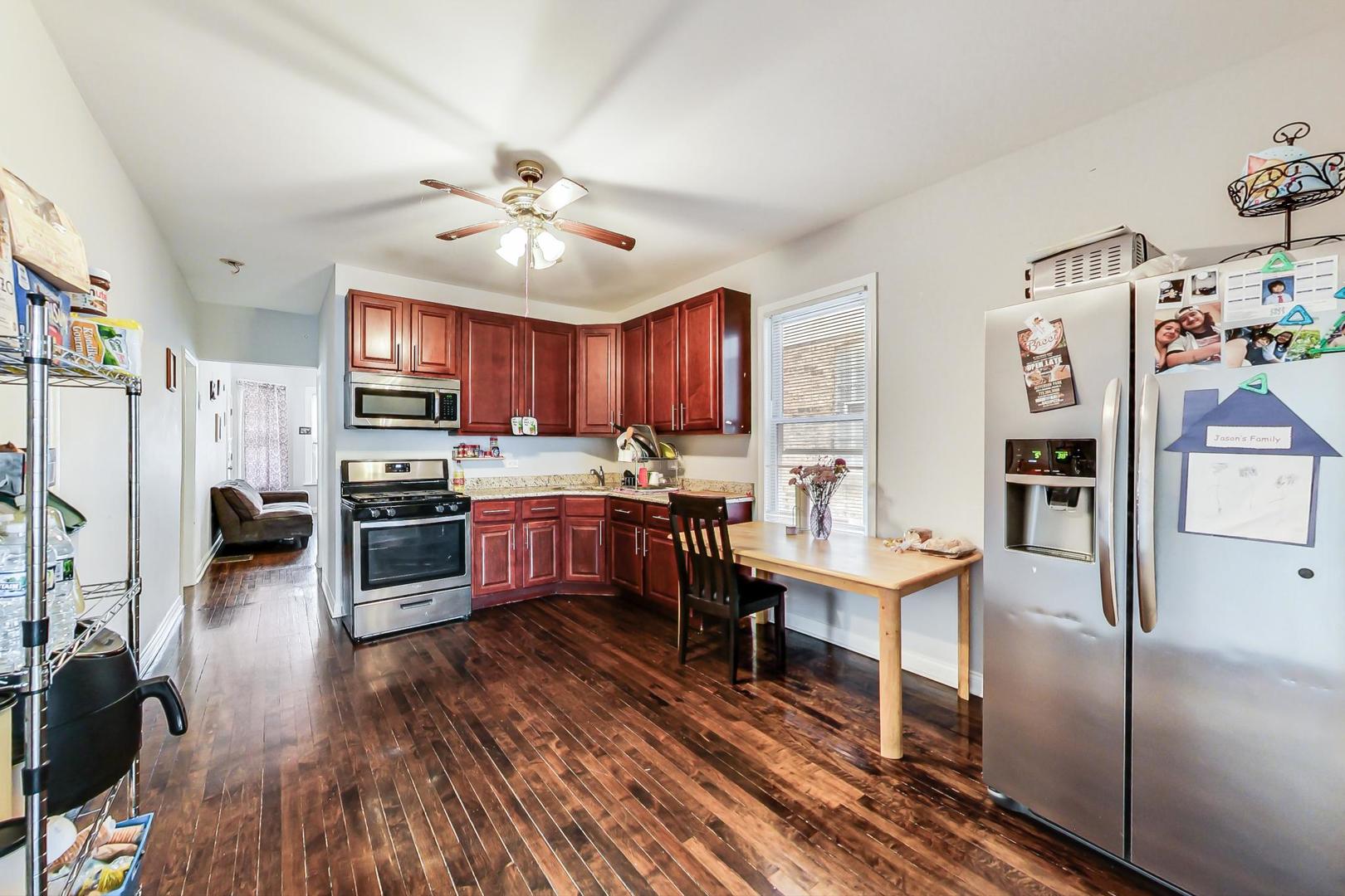 4237 West School Street Chicago, IL 60641 - Photo 10 of 72 a kitchen with stainless steel appliances a table chairs refrigerator and cabinets