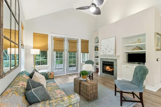 a living room with fireplace furniture and a large window