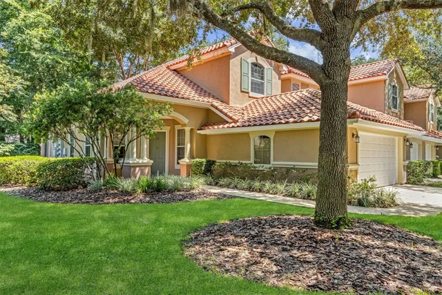 a front view of a house with a yard and green space