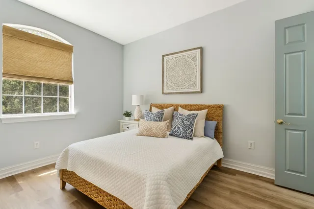 a bedroom with bed and wooden floor