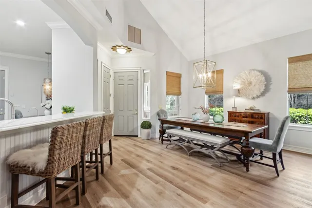 a dining room with furniture a chandelier and wooden floor