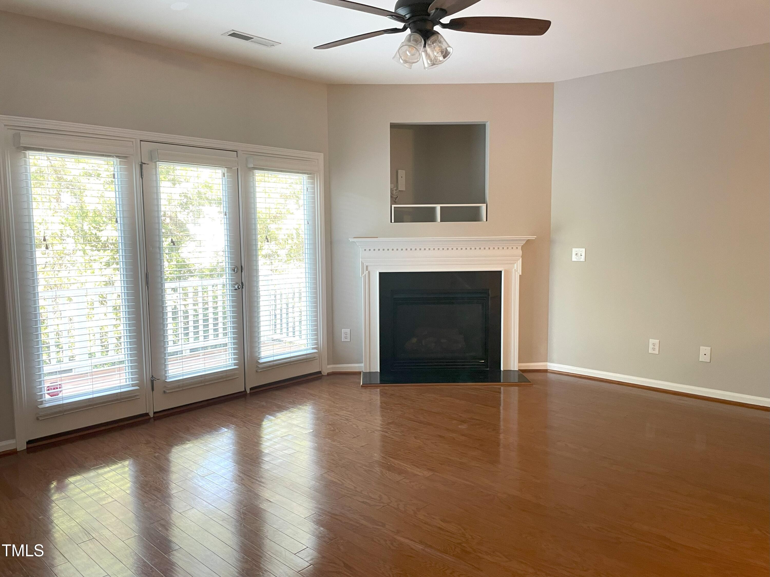 224 Broadgait Brae Road Cary, NC 27519 - Photo 6 of 19 a view of an empty room with wooden floor fireplace and a window