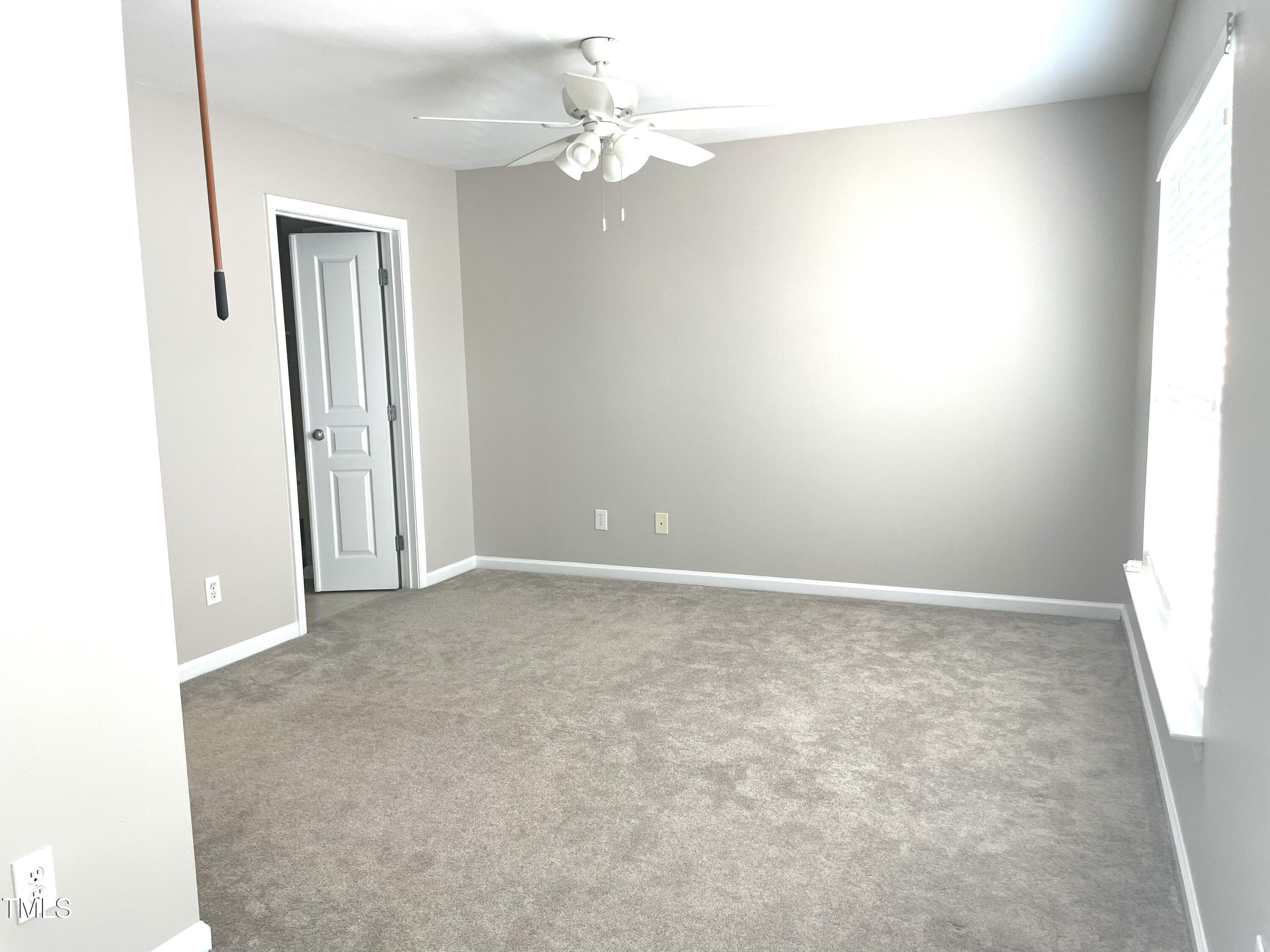 224 Broadgait Brae Road Cary, NC 27519 - Photo 9 of 19 an empty room with a chandelier fan and windows
