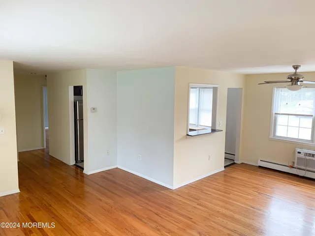 a view of kitchen and hallway with wooden floor