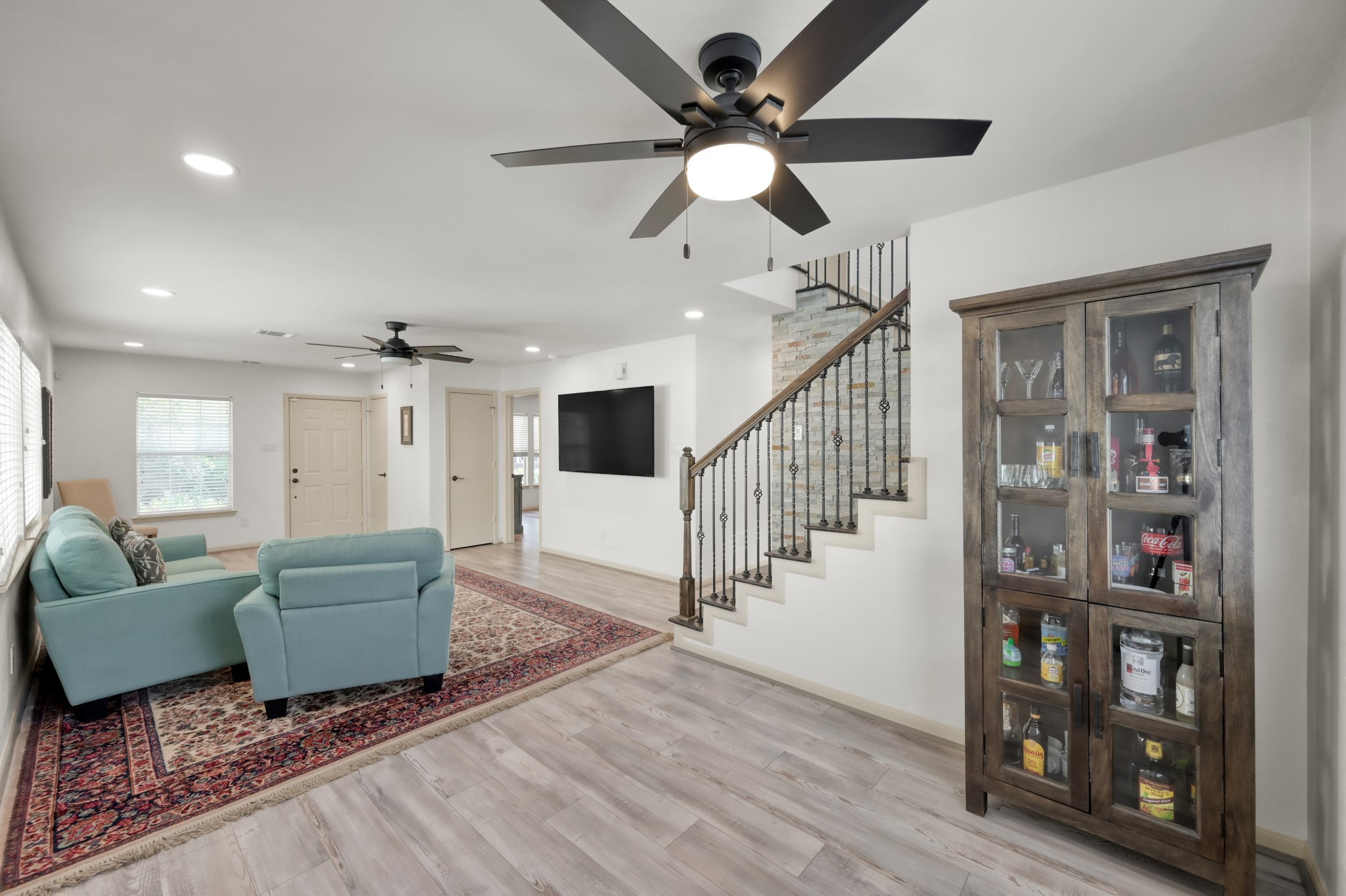 21815 Mossy Field Lane Spring, TX 77388 - Photo 9 of 39 Stunning staircase renovation featuring hardwood stairs, wrought iron railing, and custom stone accent wall.