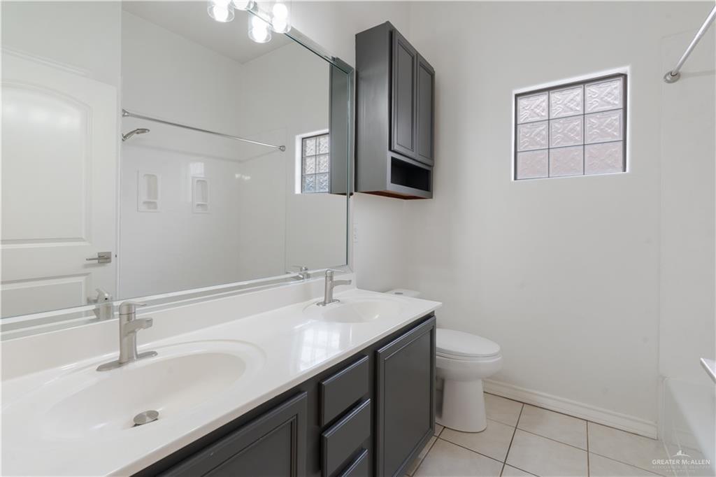 3315 Omega Street Edinburg, TX 78539 - Photo 15 of 19 Bathroom featuring double vanity, light tile patterned floors, and shower / washtub combination
