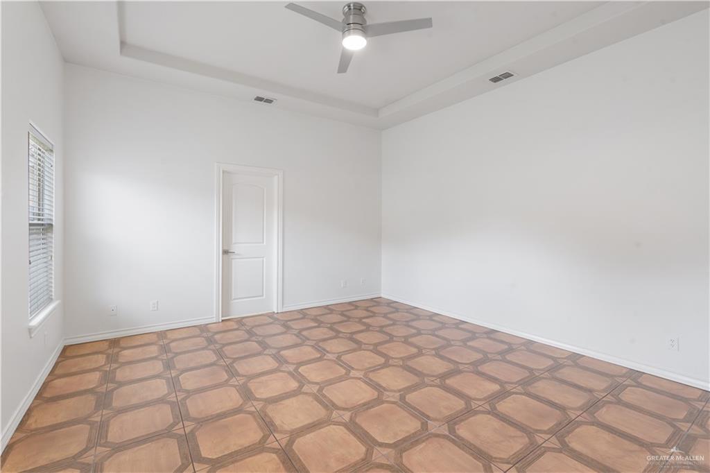 3315 Omega Street Edinburg, TX 78539 - Photo 9 of 19 Empty room featuring a raised ceiling and a ceiling fan