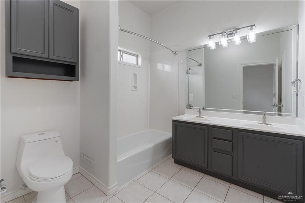 3315 Omega Street Edinburg, TX 78539 - Photo 10 of 19 Full bathroom featuring double vanity, light tile patterned flooring, and bathtub / shower combination