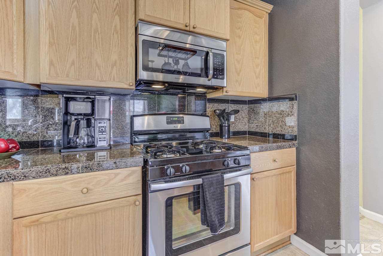 9070 Jack Hammer Drive Reno, NV 89521 - Photo 17 of 40 a kitchen with stainless steel appliances granite countertop a stove and a microwave