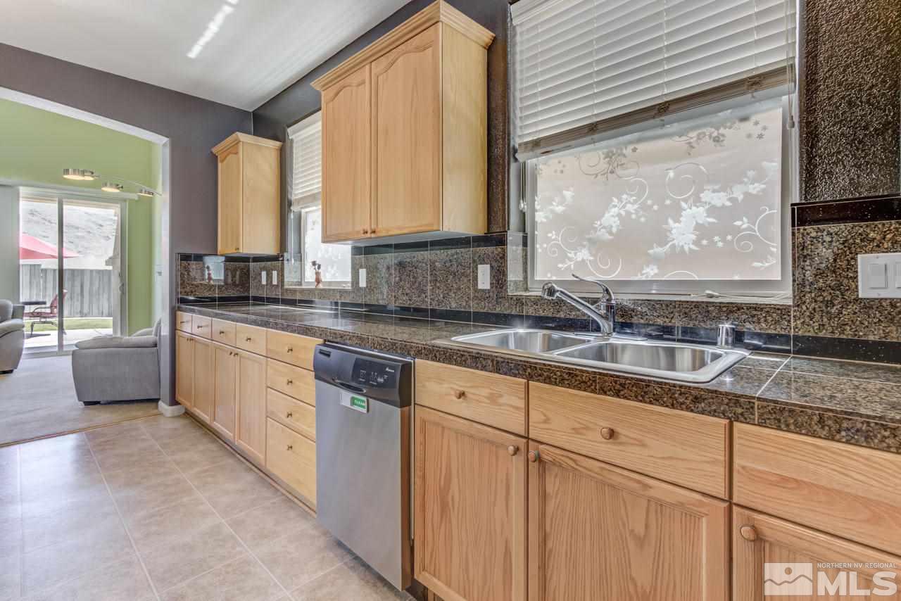 9070 Jack Hammer Drive Reno, NV 89521 - Photo 18 of 40 a kitchen with granite countertop a sink a counter top space and cabinets