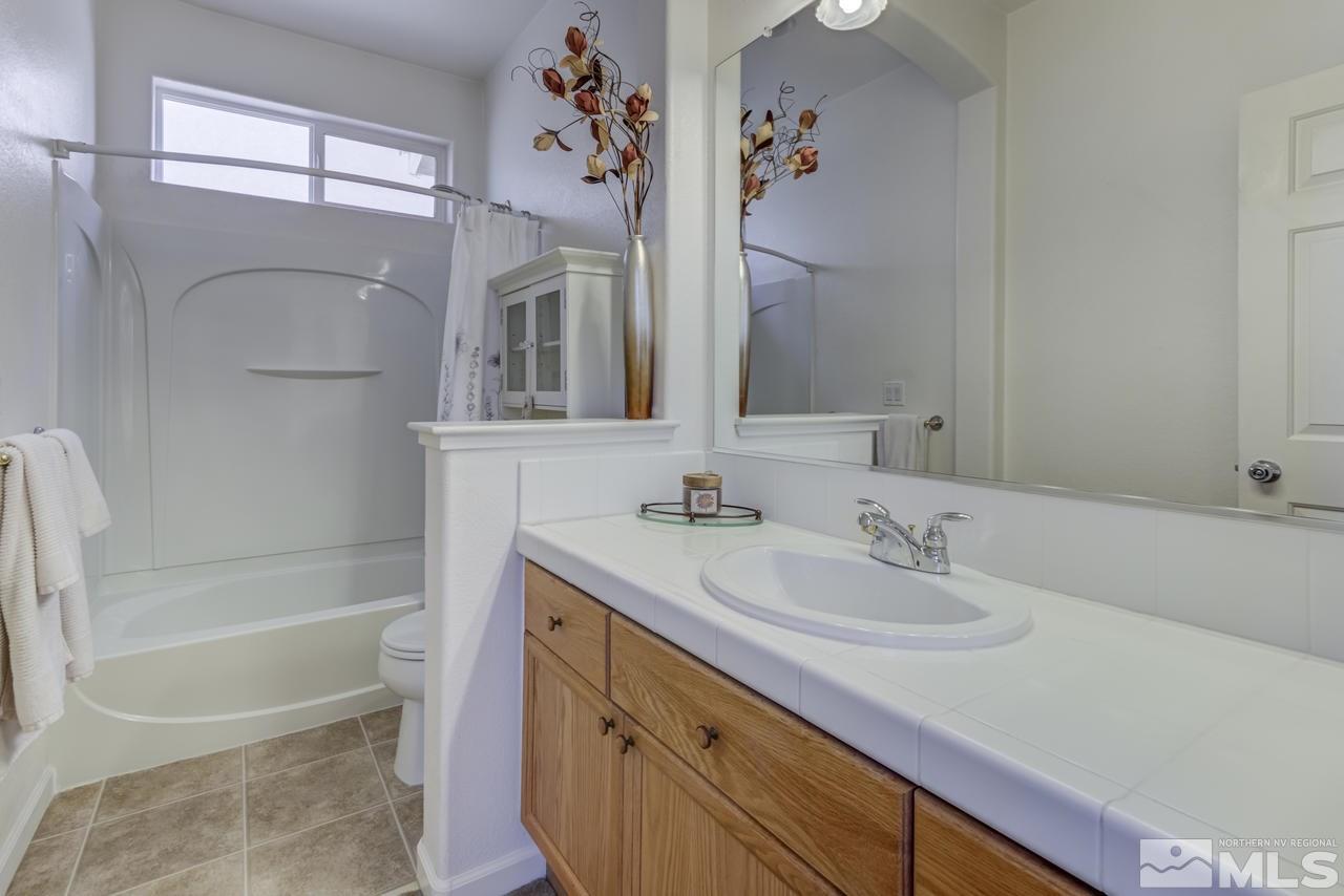 9070 Jack Hammer Drive Reno, NV 89521 - Photo 32 of 40 a bathroom with a tub sink and mirror