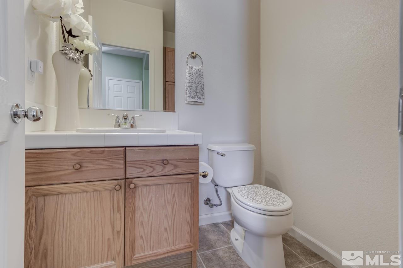 9070 Jack Hammer Drive Reno, NV 89521 - Photo 35 of 40 a bathroom with a granite countertop toilet sink and mirror