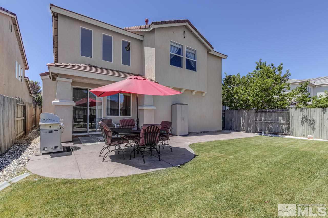 9070 Jack Hammer Drive Reno, NV 89521 - Photo 39 of 40 a patio with a table and chairs under an umbrella