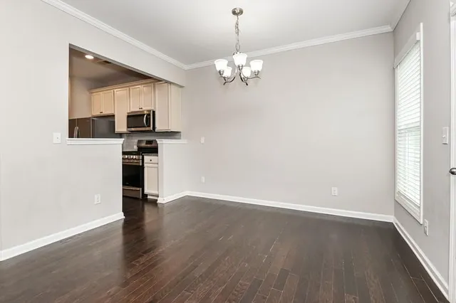 a view of a kitchen with wooden floor and a ceiling fan