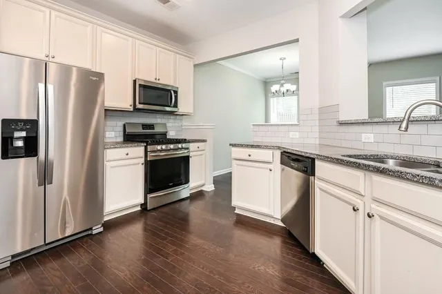 a kitchen with white cabinets and stainless steel appliances