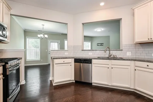 a kitchen with granite countertop white cabinets and white appliances