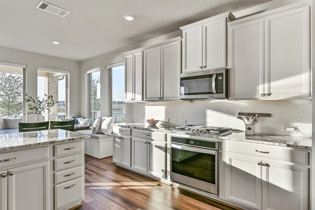 a living room with furniture a view of bedroom and a flat screen tv