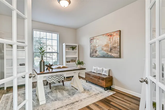a view of a kitchen with kitchen island a large window cabinets a sink and stainless steel appliances