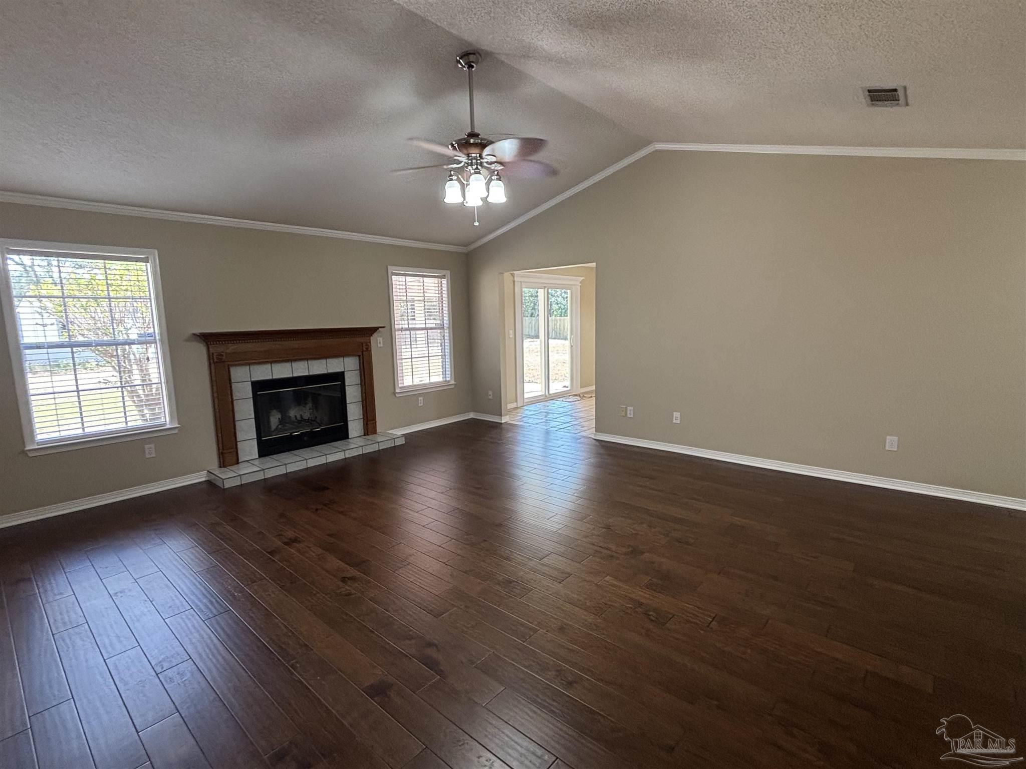 5309 Gillette Way Milton, FL 32570 - Photo 5 of 51 an empty room with wooden floor fireplace and windows