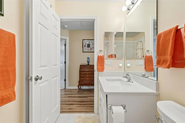 a bathroom with a sink and mirror with toilet
