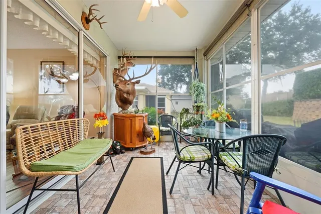 a dining room with furniture a chandelier and glass door