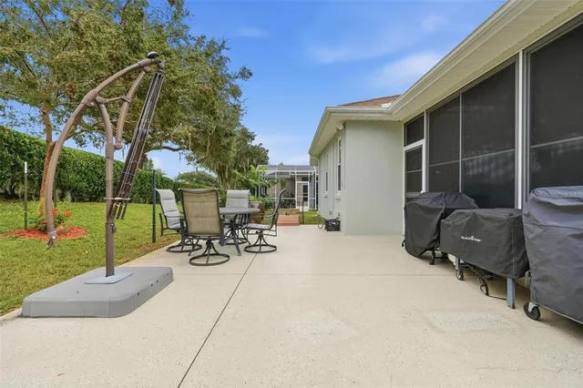 a view of a backyard with table and chairs and a barbeque
