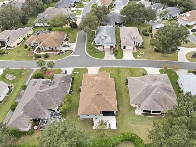 an aerial view of residential houses with outdoor space and parking