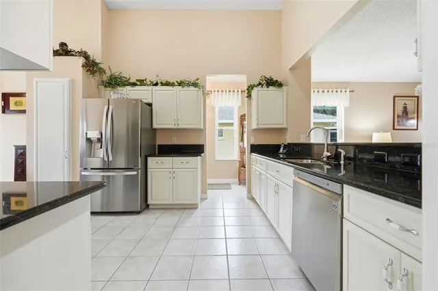 a large white kitchen with a stove a refrigerator and a sink