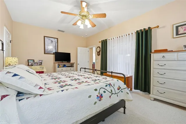 a bedroom with a bed dresser and a flat tv screen