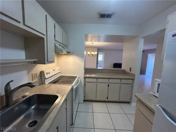 a kitchen with stainless steel appliances granite countertop a refrigerator a stove and a sink