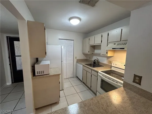 a kitchen with granite countertop a sink and a stove top oven