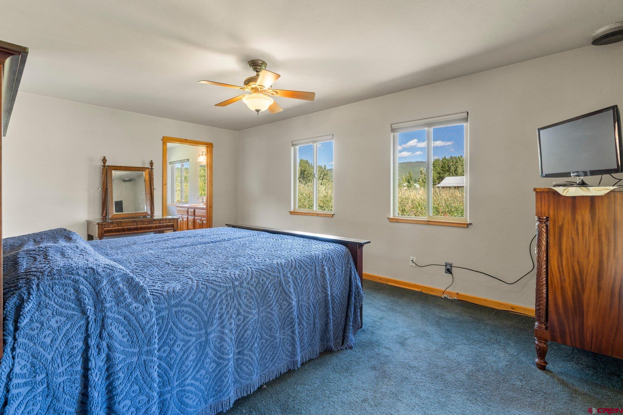 115 Pine River Ranch Circle Bayfield, CO 81122 - Photo 13 of 30 a bedroom with a bed and a chandelier